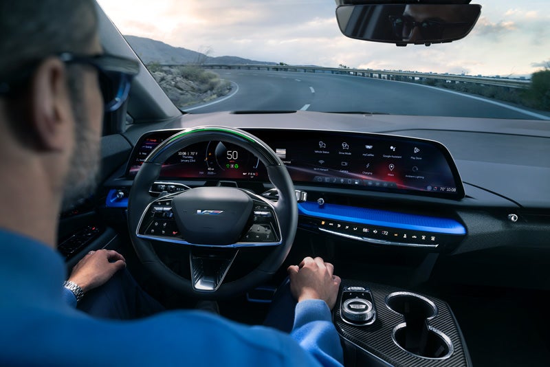 Front View of the 2026 OPTIQ-V Driving Through the Dusk Utilizing its Headlights | Braden Cadillac in CARROLL OH